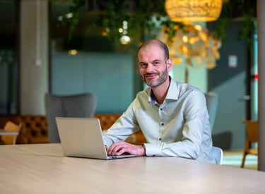 Jasper van Dieten-Blom, founder of Treeline Consulting, working on a laptop in modern office setting