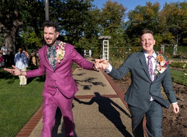 Two grooms dacing, smiling post wedding ceremony, captured by Canberra photographer
