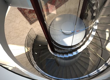 Staklena ograda spiralnog stepeništa napravljena od zakrivljenog stakla koje prati oblik stepenica