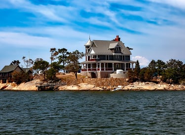 a house on a small island with a boat in the water