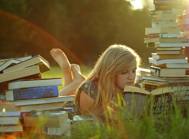 a woman laying on a pile of books