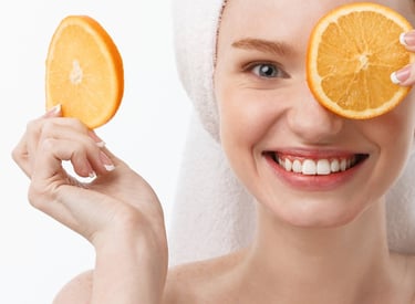 Vrouw met handdoek op haar hoofd en een appelsien voor haar ogen