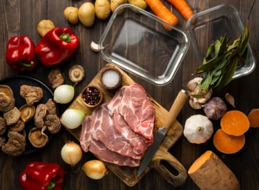 a variety of vegetables and meat on a wooden table