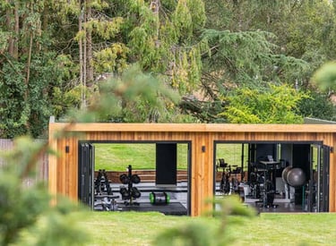 a wooden garden pod gym with fitness equipment