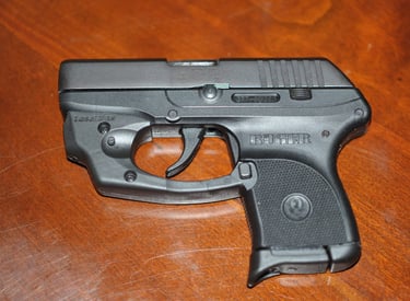 Ruger LCP with laser laying on a wood table