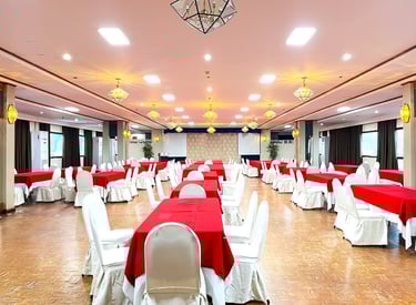 a large event function room with tables and chairs and red tablecloth