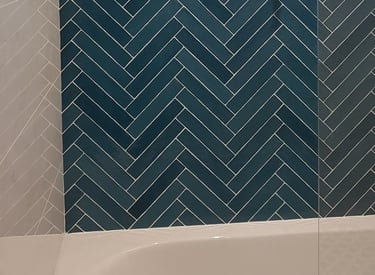 Jolie faïence verte, petites format posé en chevron autour d'une baignoire