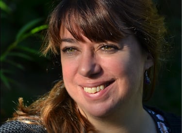 Une femme, Elodie Forget avec un chemisier à fleurs et un gilet noir
