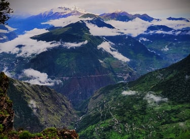 Mountain ridges with clouds and distant snowy peaks