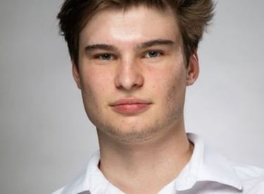 a man with a very short haircut and a white shirt