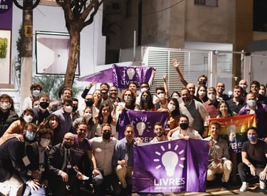 foto de associados do Livres segurando bandeiras do livres na frente da casa livres