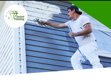 Garnet Painting team working on exterior house painting with company logo visible”