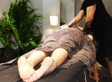 Client receiving a back massage in a calming wellness studio in North West London, promoting relaxat