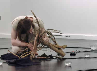 performance artist with wooden sculpture