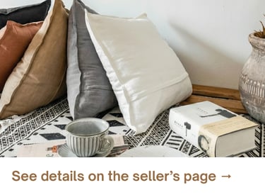 Neutral throw pillows layered on a cozy bed, creating a soft, relaxed look with simple textures and