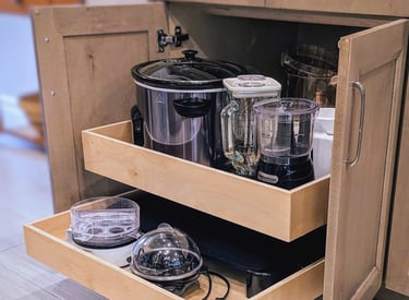 A cabinet drawer is extended out from the cabinet showing heavy kitchen appliances.