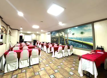 a meeting room with tables and chairs and red tablecloth a projector