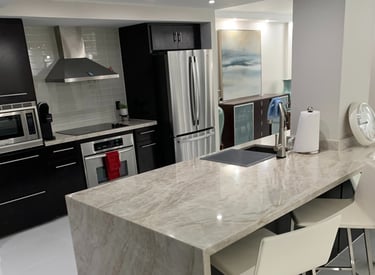 a kitchen with a marble counter top and chairs