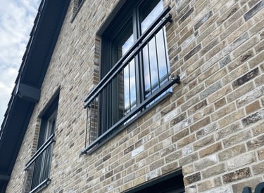 Individuell gefertigtes Fenstergeländer aus pulverbeschichtetem Stahl am Haus