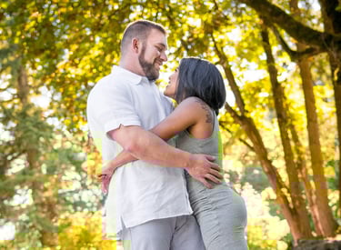 a man and woman standing in front of a tree