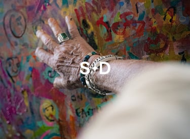 Artist Stevendick.art hand on colorful painting for BrandNests branding and social strategy.