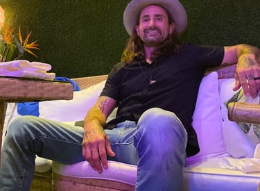 a man sitting on a couch with a hat on