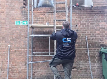 a man in cs cleaning and ducting company workwear fixing ducting