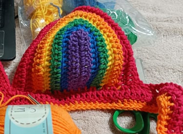 Bikini top de crochet arcoíris hecha a mano, confeccionada con hilo naranja.
