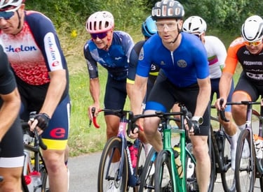 a group of cyclists mid race on a road