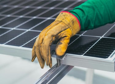 a person wearing gloves and gloves holding a solar panel