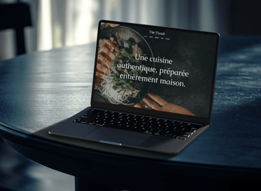 A laptop on a table displaying the Pho Paradis website