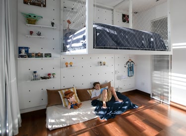 a young boy sitting on a bed in a loft apartment
