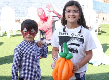 Kids posing with a pumpkin balloon