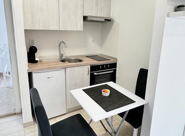 kitchen with coffe machine, fridge table and chairs