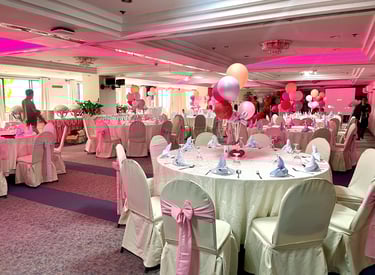 a function room with a table and chairs and balloons for birthday celebration