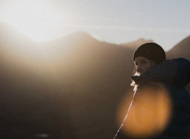 a photo of sunny winetr day in the mountains of scotland girl in a hat