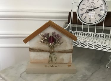 décoration en bois en forme de maison avec des fleurs séchées