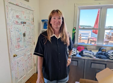 Ellen standing in front of a table with t-shirts on it