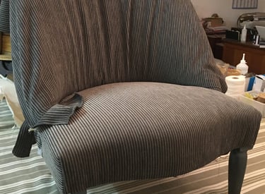 Chauffeuse recouverte d'un tissu en train d'être posé