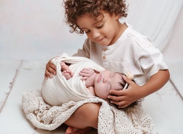 a young child is holding a newborn baby