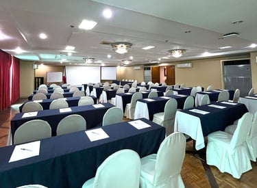 a meeting room with several tables and chairs and a projector for business and government events