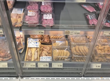 Das Bild zeigt ein Kühlregal mit sehr viel billigem und abgepacktem Fleisch