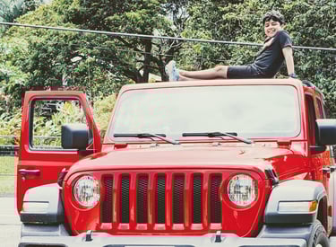 Kid on roof top of a Red Jeep Wrangler 4X4, Highway to Hana, Maui, Hawaii