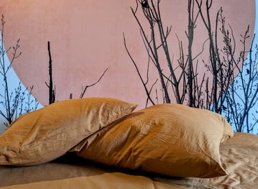 un lit avec une literie orange et une tête de lit ensoleillée