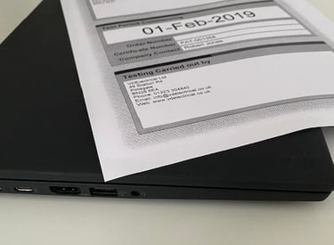 a laptop computer sitting on a desk with a paper document