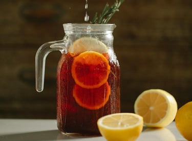 a person squeezing lemonade into a jar of lemonade