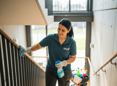 a woman in a green shirt cleaning stairs
