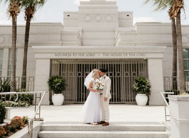 a bride and groom standing in front of a temple