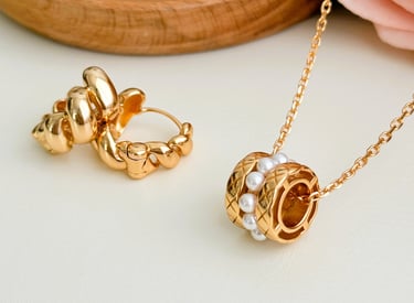 eine goldene Halskette mit Perlen und Perlen daran