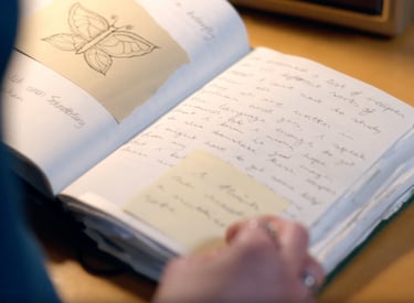 a person holding a book with a butterfly on it